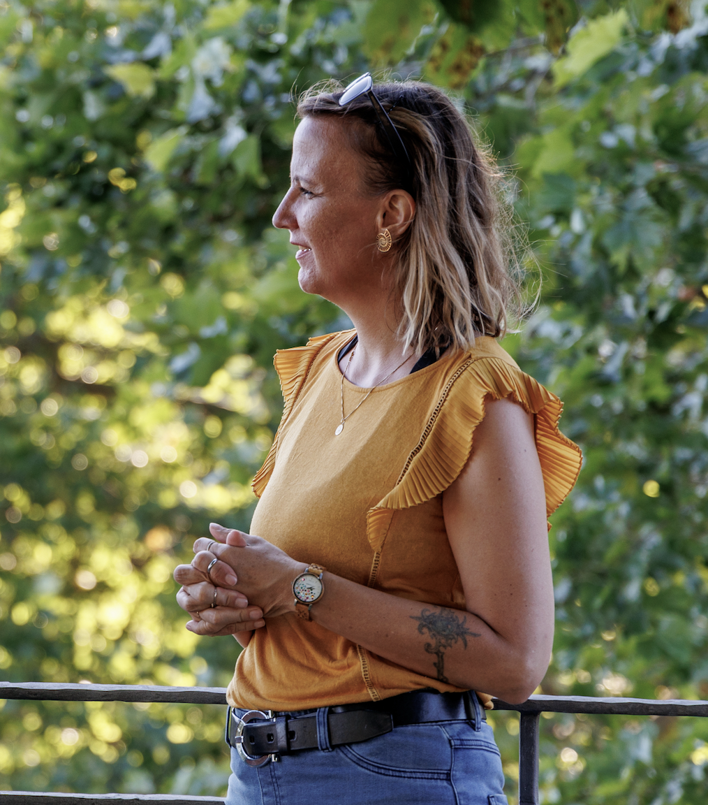 Tanja Hoyer im Profil vor grünem Laub